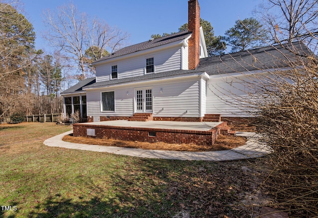 rear view of house with a patio area, a sunroom, and a yard