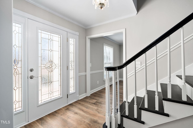 entryway featuring wood-type flooring, crown molding, and a notable chandelier