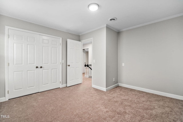 unfurnished bedroom featuring carpet flooring, crown molding, and a closet