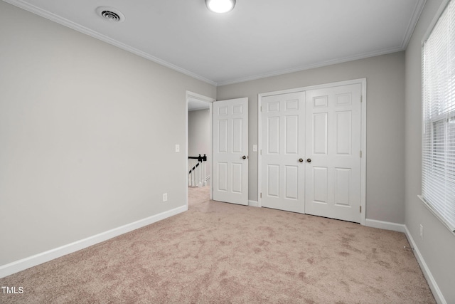 unfurnished bedroom featuring light carpet, a closet, and crown molding