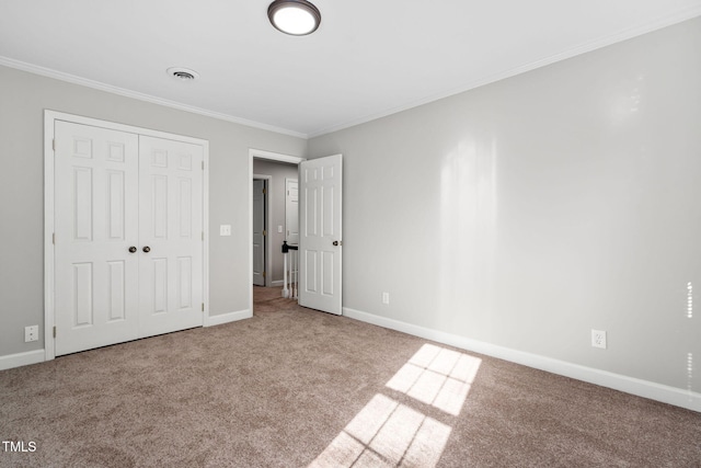 unfurnished bedroom with light colored carpet, crown molding, and a closet