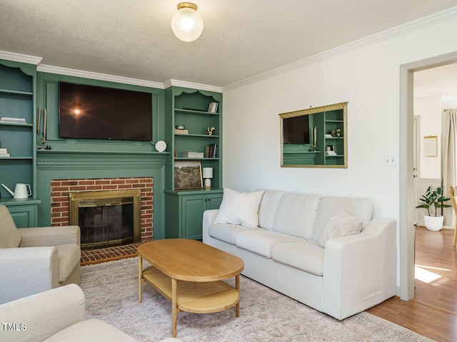 living room featuring a textured ceiling, light hardwood / wood-style flooring, crown molding, and a fireplace