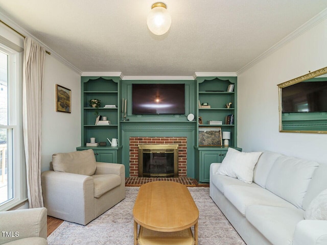 living room with a textured ceiling, light hardwood / wood-style floors, a brick fireplace, and crown molding