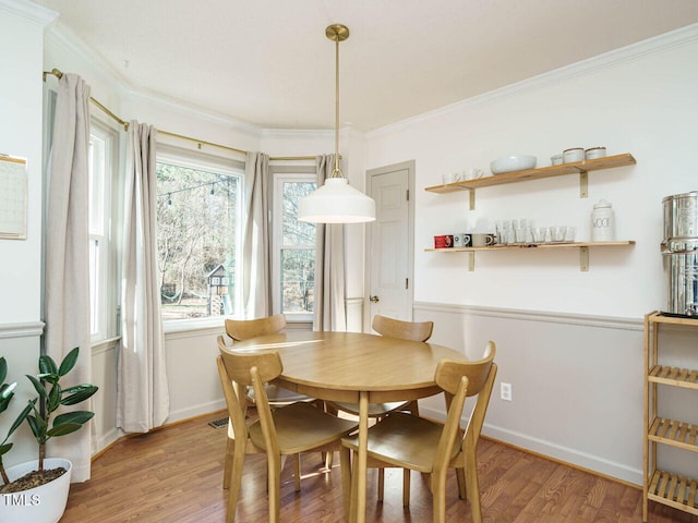 dining area featuring ornamental molding and light hardwood / wood-style floors