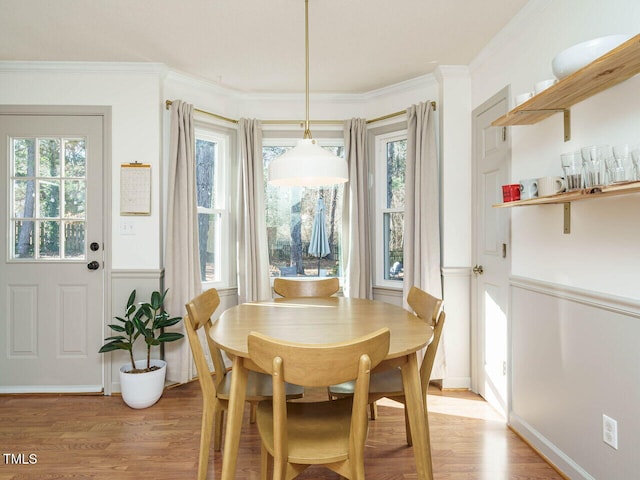 dining space with light hardwood / wood-style floors and crown molding