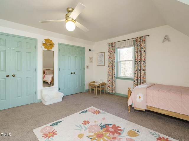 bedroom with lofted ceiling, carpet floors, ceiling fan, and multiple closets