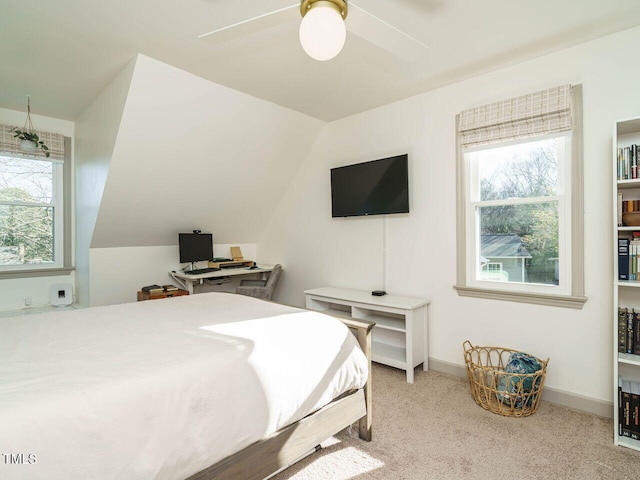 bedroom featuring lofted ceiling, ceiling fan, light carpet, and multiple windows