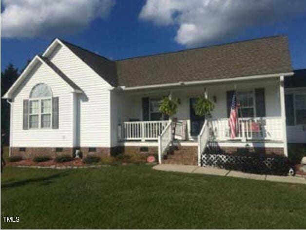 view of front of home with covered porch and a front lawn