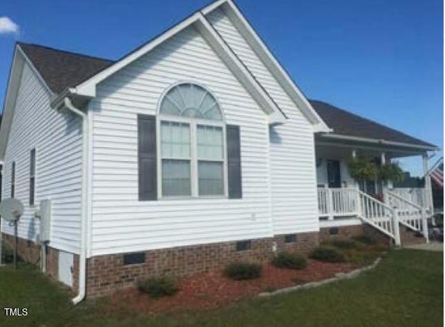 view of front of home with covered porch and a front lawn