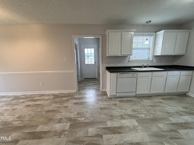 kitchen featuring dishwasher, sink, white cabinets, and a textured ceiling