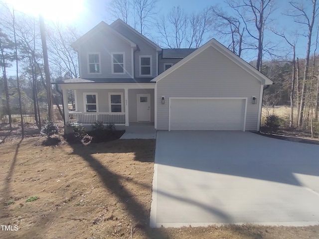 view of front facade with a garage, covered porch, and driveway