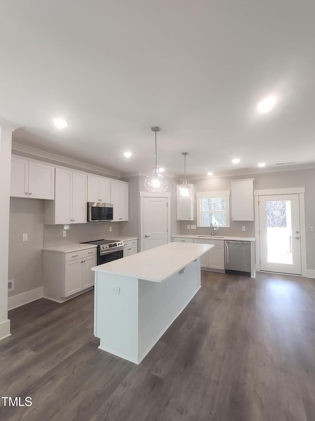 kitchen featuring white cabinets, appliances with stainless steel finishes, light countertops, and a sink