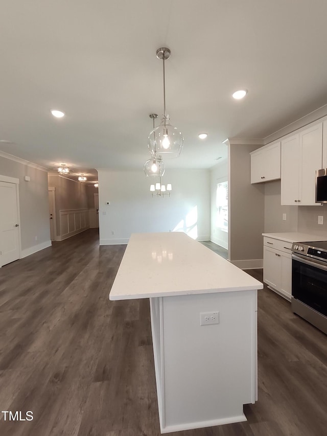 kitchen featuring appliances with stainless steel finishes, white cabinetry, a kitchen island, and crown molding