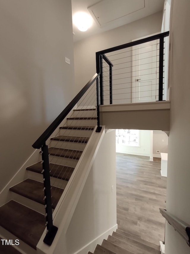 staircase with wood finished floors and baseboards