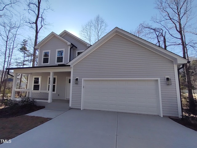 view of front facade with a garage, covered porch, and driveway