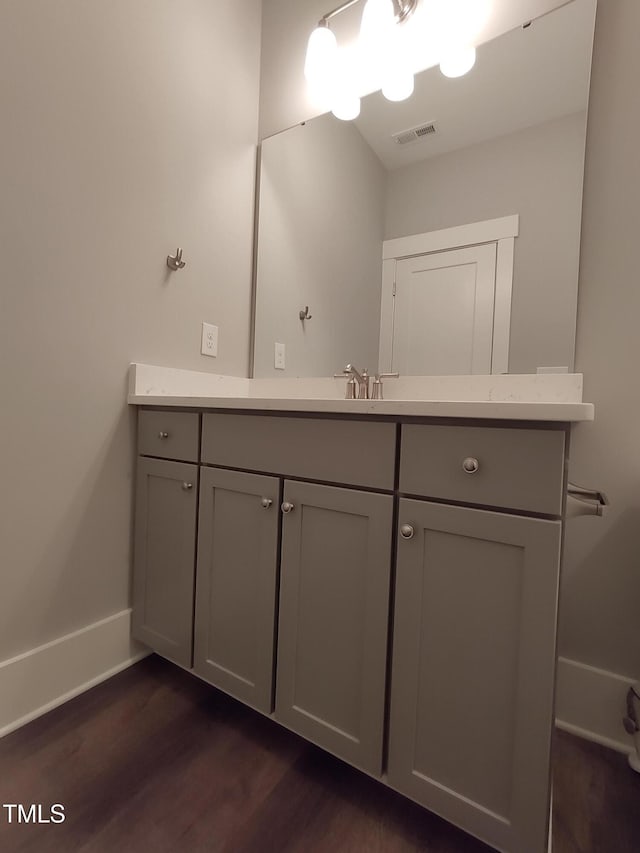 bathroom featuring vanity, wood finished floors, visible vents, and baseboards