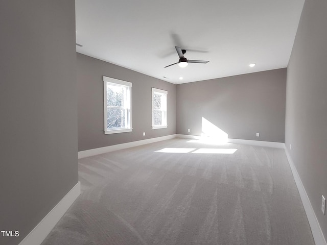 unfurnished room with light carpet, a ceiling fan, and baseboards