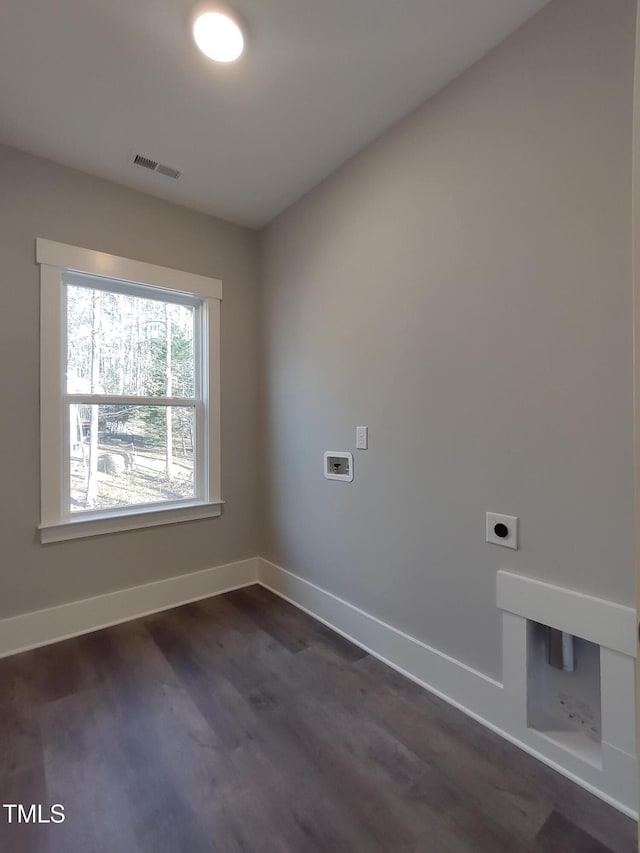 unfurnished room with dark wood-style flooring, visible vents, and baseboards