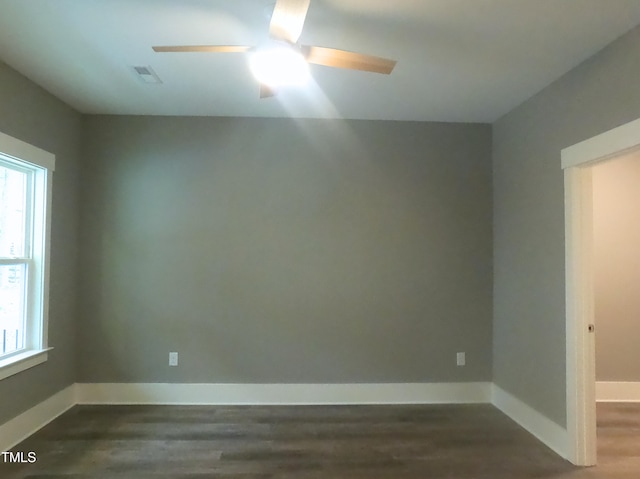 empty room featuring ceiling fan, wood finished floors, visible vents, and baseboards