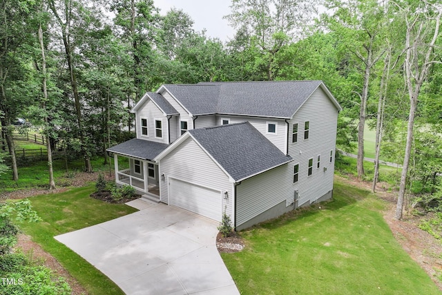 632 Angus Ct, Sanford, NC 27332 - traditional home with a shingled roof, covered porch, concrete driveway, a garage, and view of scattered trees