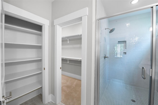 632 Angus Ct, Sanford, NC 27332 - bathroom with a walk in closet, a stall shower, and baseboards