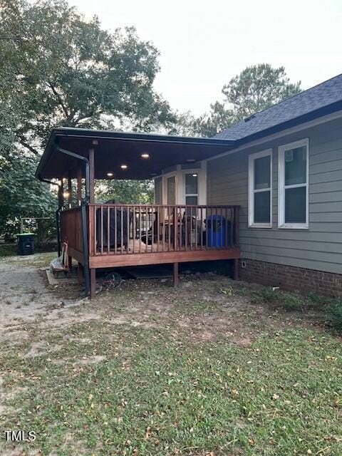 rear view of house with a wooden deck and a yard