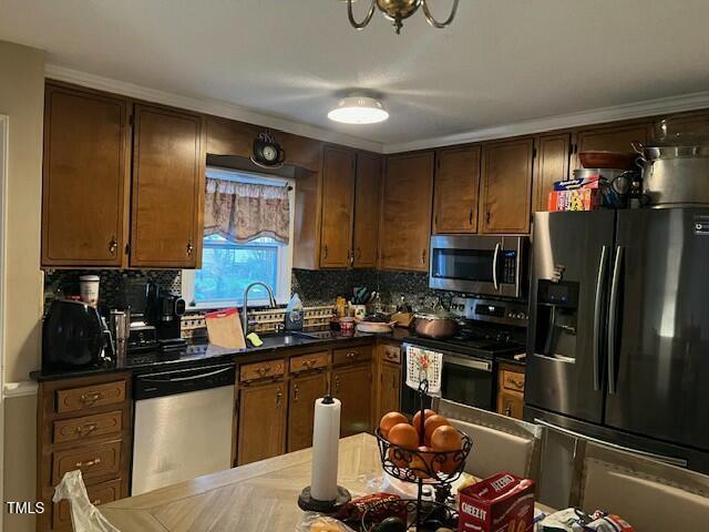 kitchen featuring stainless steel appliances, sink, and backsplash