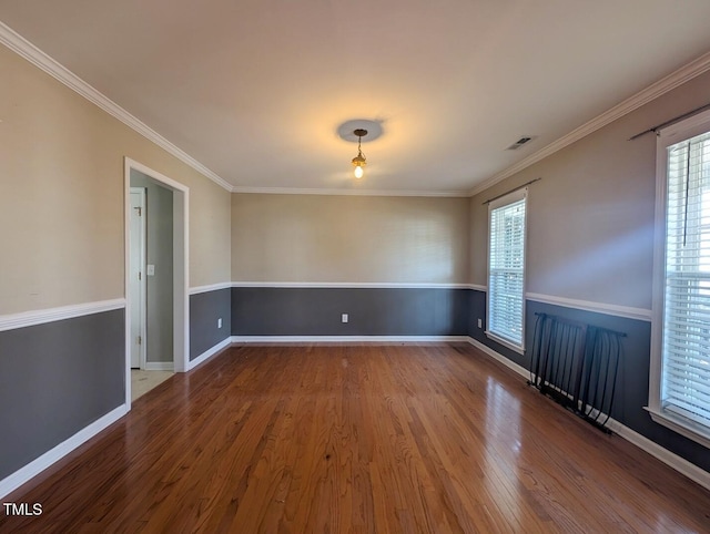 empty room featuring wood-type flooring and ornamental molding