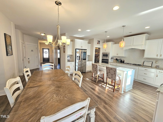 dining area featuring a chandelier and light wood-type flooring