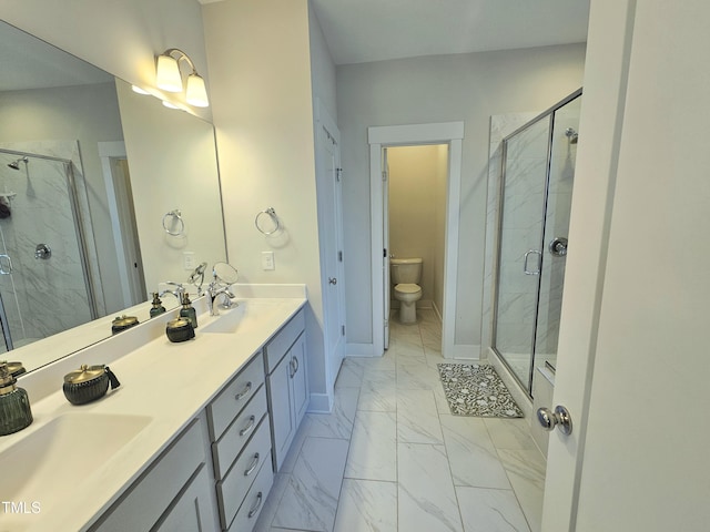 bathroom with vanity, toilet, and a shower with door