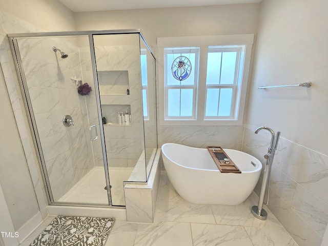 bathroom with plenty of natural light, independent shower and bath, and tile walls