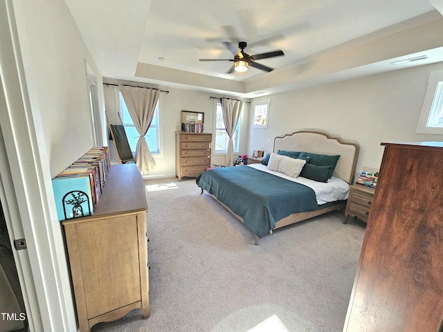 bedroom featuring a tray ceiling, ceiling fan, and light colored carpet