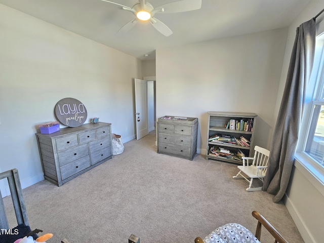 living area with ceiling fan and light colored carpet