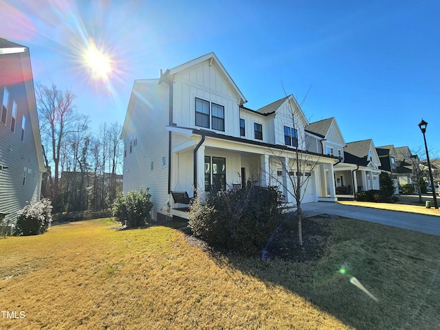 view of front of home with a yard, covered porch, and a garage