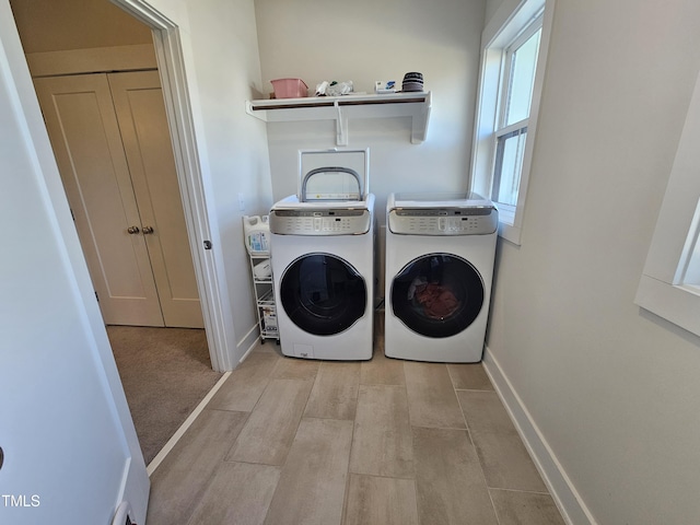 laundry room with laundry area, baseboards, and washer and clothes dryer