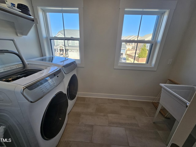 laundry room with laundry area, baseboards, and separate washer and dryer