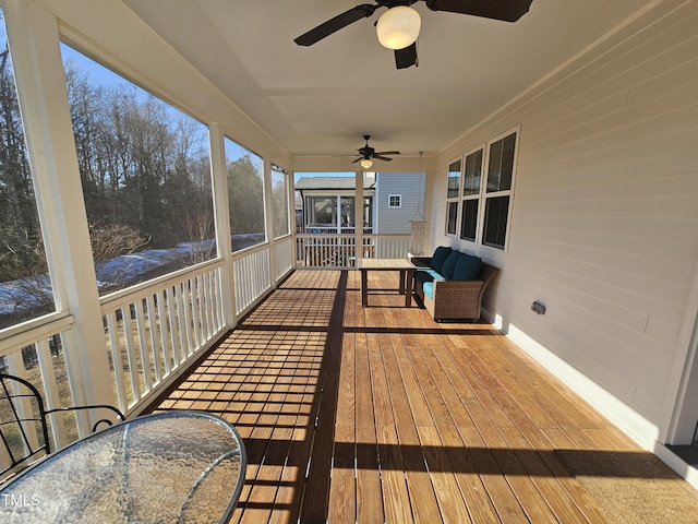 wooden deck featuring outdoor dining area and a ceiling fan