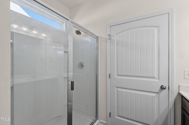 bathroom featuring vanity and a shower with shower door