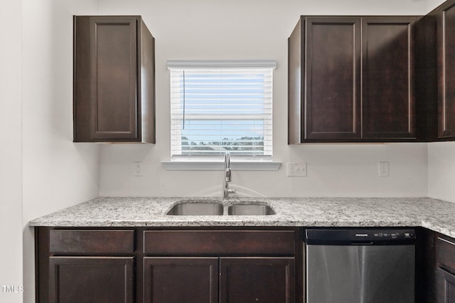 kitchen featuring light stone countertops, dark brown cabinets, stainless steel dishwasher, and sink