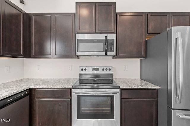 kitchen featuring light stone counters, dark brown cabinets, and stainless steel appliances