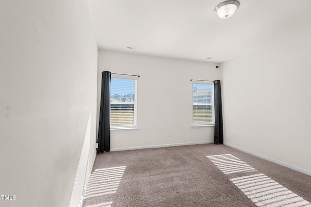 spare room with a wealth of natural light and light colored carpet