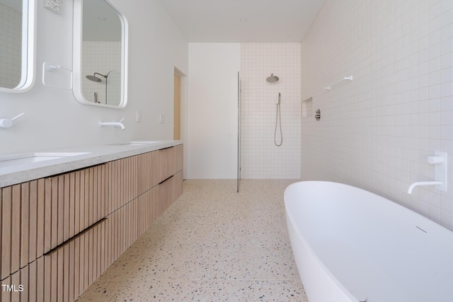 bathroom featuring vanity, separate shower and tub, and tile walls