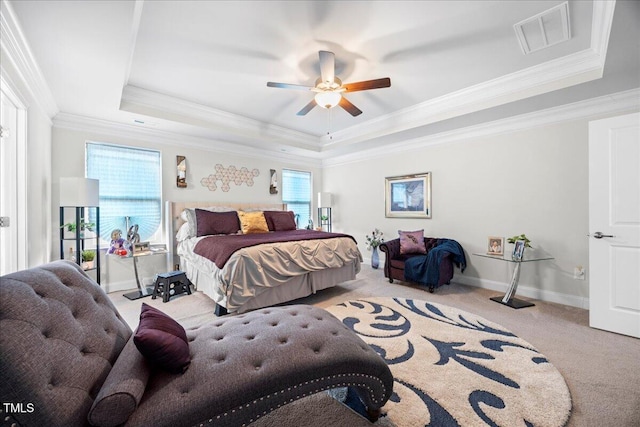 carpeted bedroom with a raised ceiling, ceiling fan, and ornamental molding