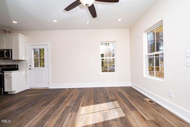 unfurnished living room with ceiling fan and dark wood-type flooring