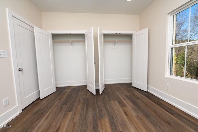 unfurnished bedroom with multiple closets and dark wood-type flooring