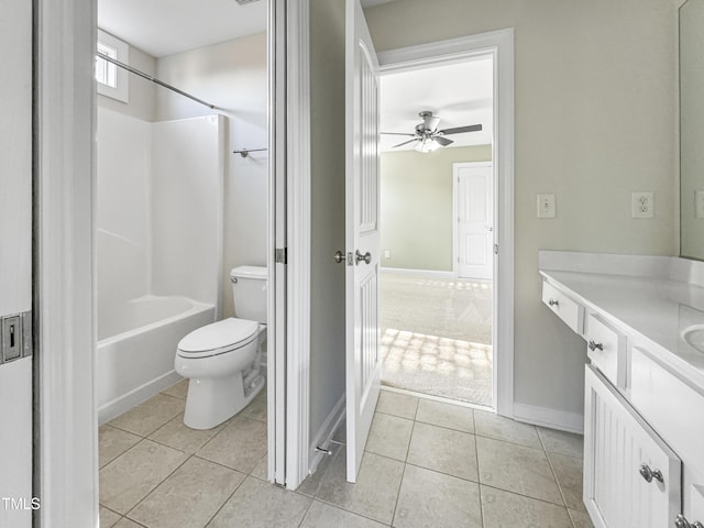 bathroom featuring toilet, vanity, baseboards, shower / washtub combination, and tile patterned floors