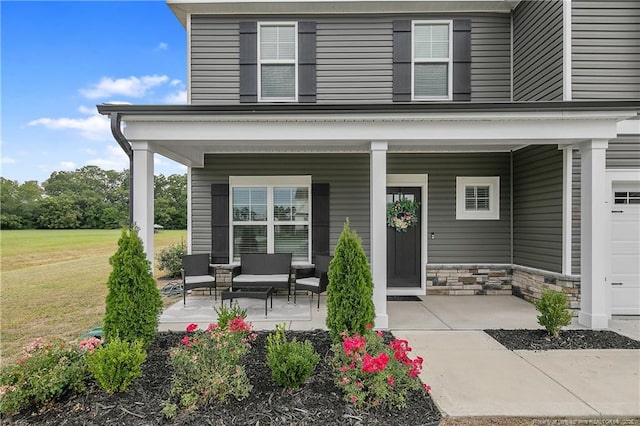 entrance to property with outdoor lounge area, covered porch, and a yard