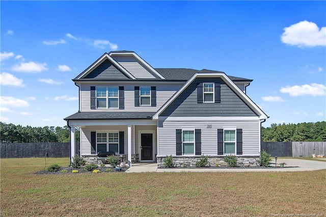 craftsman-style house featuring covered porch and a front yard