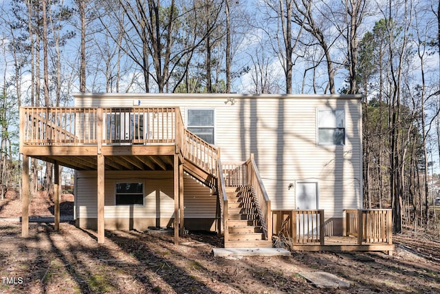 rear view of house featuring a wooden deck and stairs