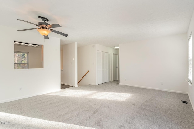 spare room featuring carpet, visible vents, and baseboards